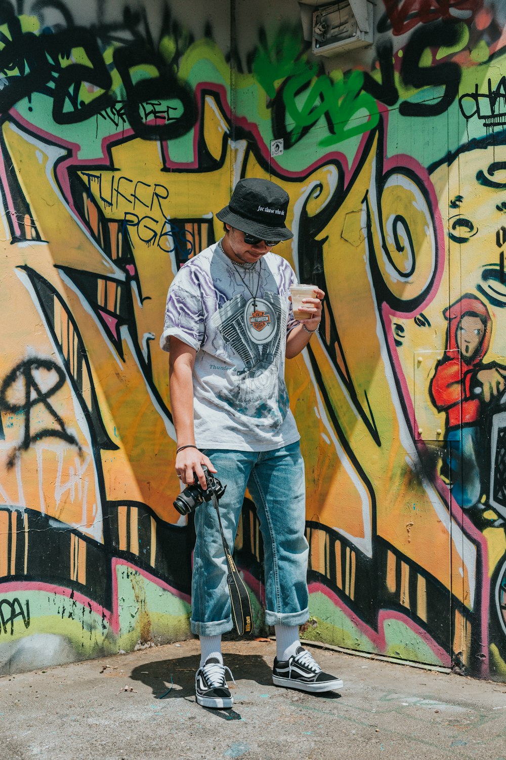 man in grey crew neck t-shirt and blue denim jeans standing beside graffiti  wall photo – Free Human Image on Unsplash