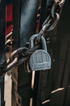 silver padlock on black steel gate