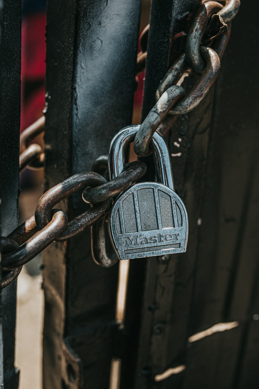 silver padlock on black steel gate