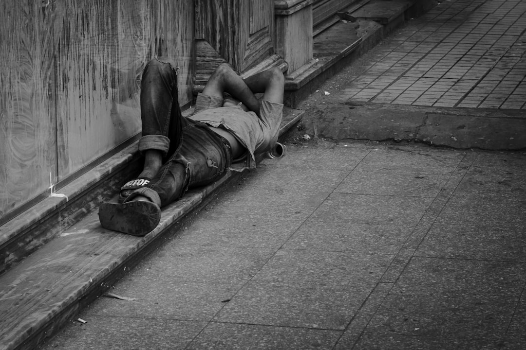 man in black t-shirt and black pants lying on concrete floor
