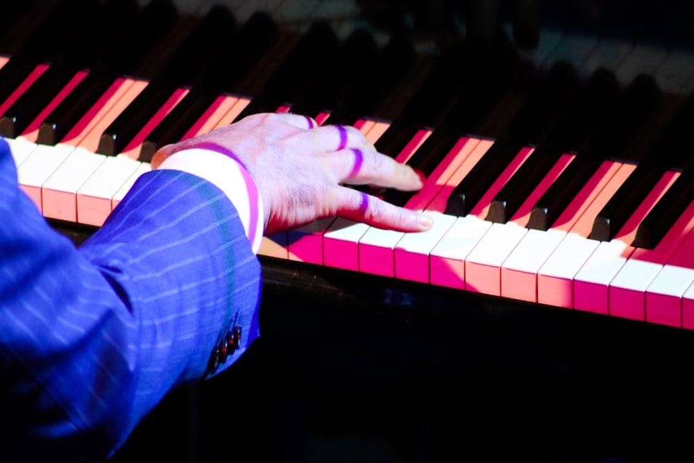 person in blue denim jeans playing piano