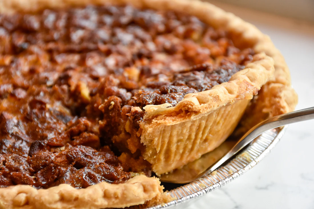 A pecan pie on a white ceramic plate