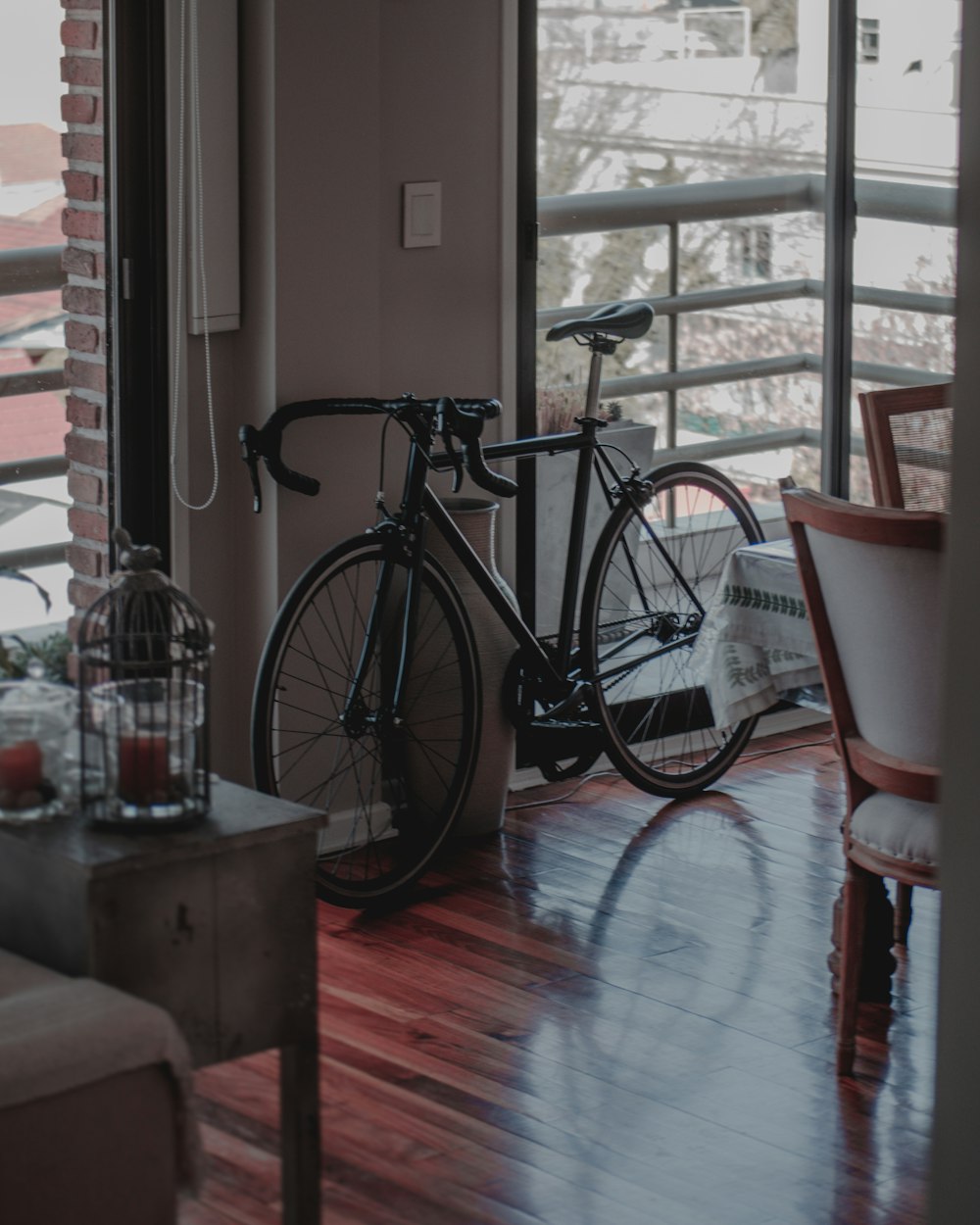 vélo de ville noir près de la fenêtre en verre