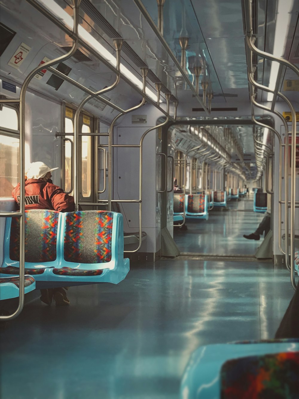 woman in red and white plaid shirt sitting on blue and white train seat