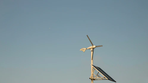 Wind turbines spinning against a clear blue sky, symbolizing sustainable energy.