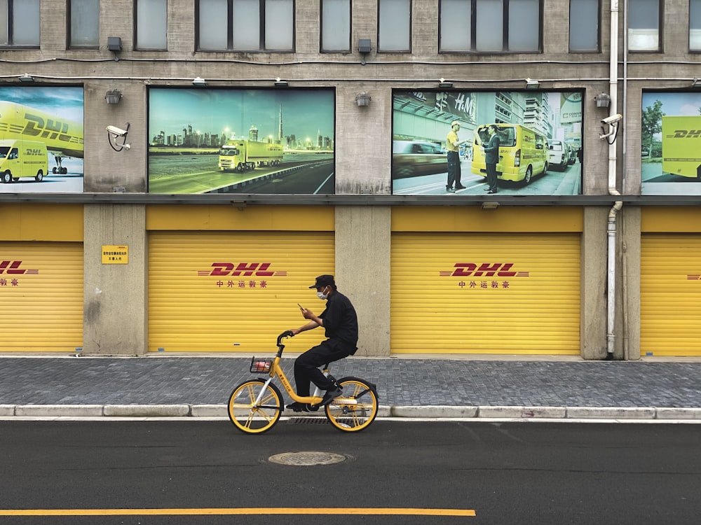 man in black jacket riding bicycle on sidewalk during daytime