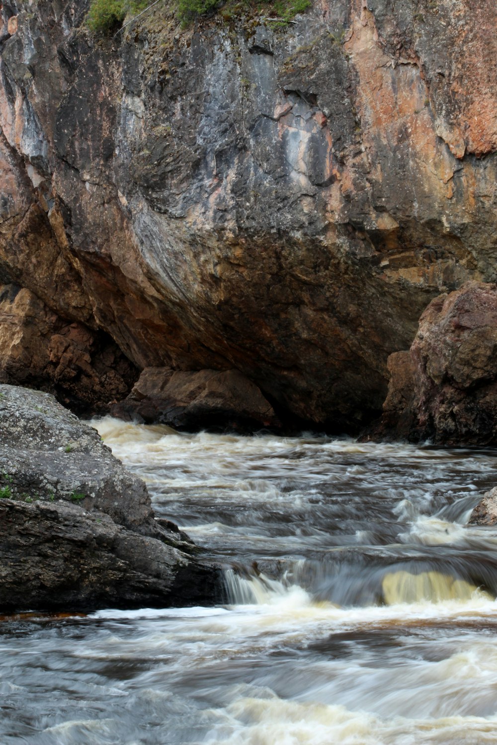 water falls between brown rock formation during daytime