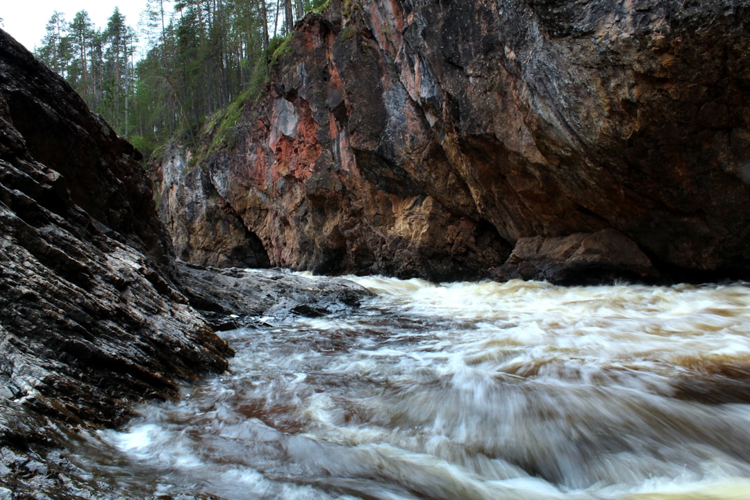 brown rocky mountain beside river during daytime