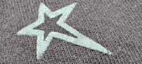 A close-up of fabric patterns featuring celestial designs like stars and planets.