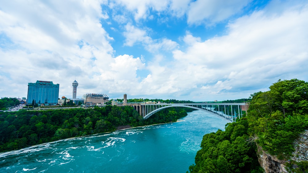 bridge over river under cloudy sky during daytime