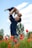 man in blue long sleeve shirt carrying baby in white onesie