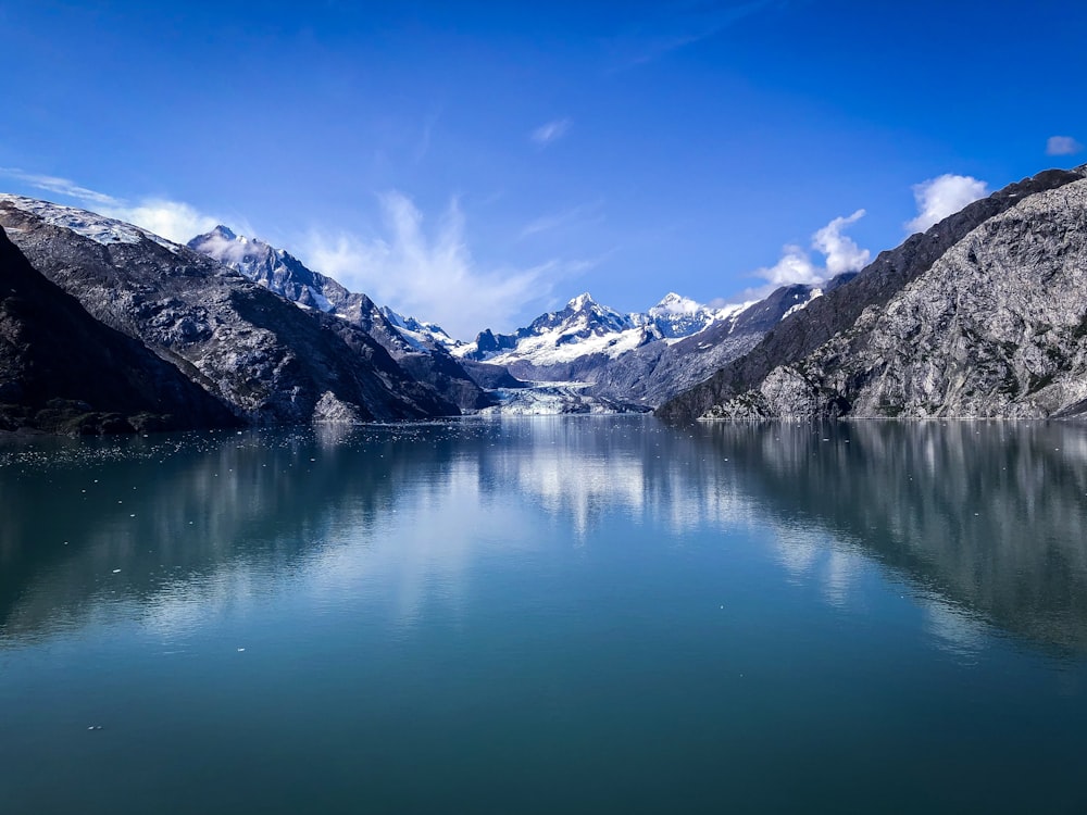 lac près de la montagne enneigée sous ciel bleu pendant la journée