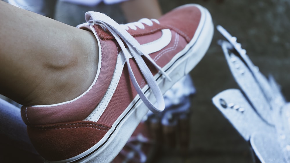 person wearing orange and white nike athletic shoes