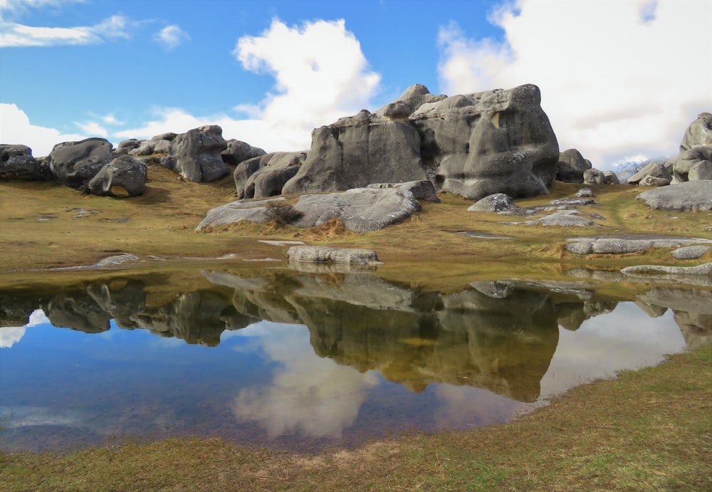 gray rock formation beside body of water during daytime