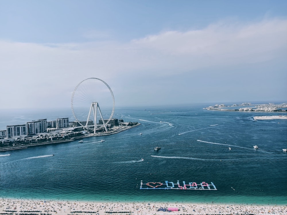 white ferris wheel near body of water during daytime