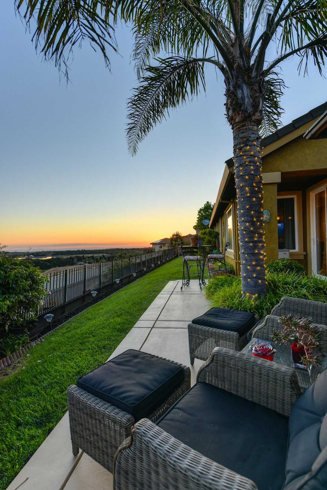 black metal chairs and tables near palm trees during sunset