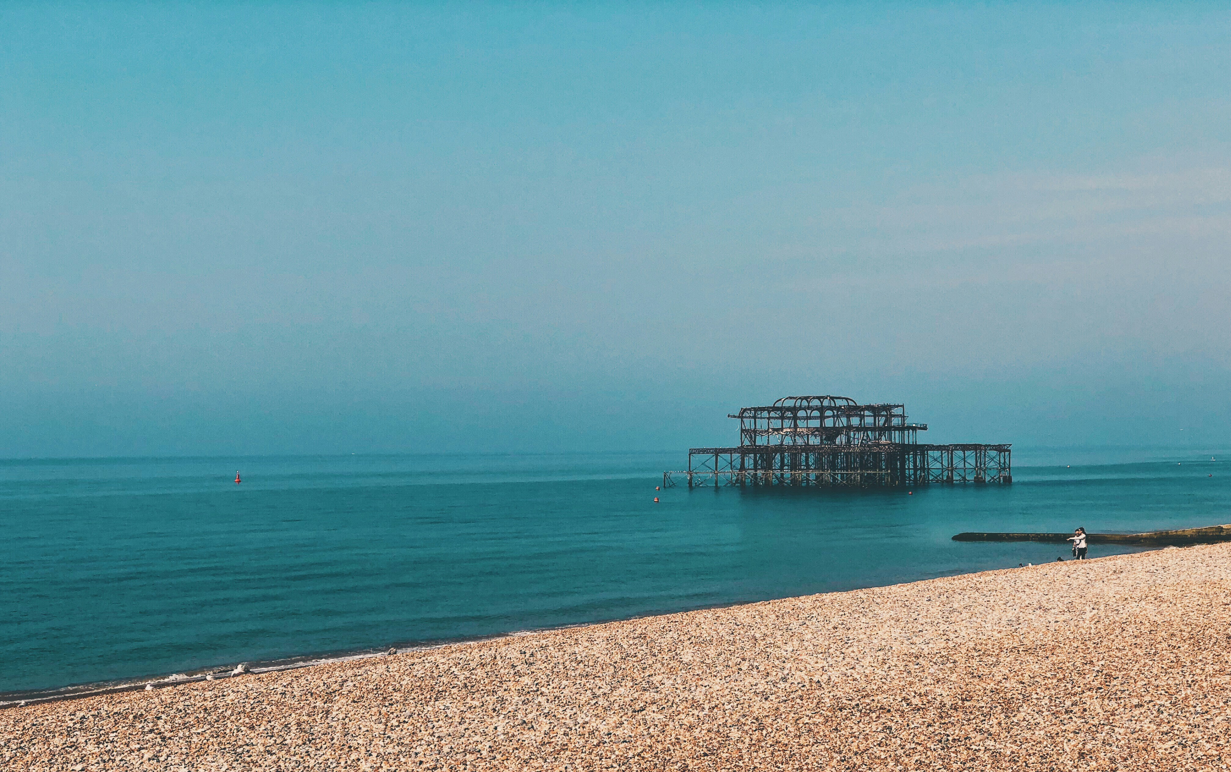 blue wooden dock on blue sea under blue sky during daytime
