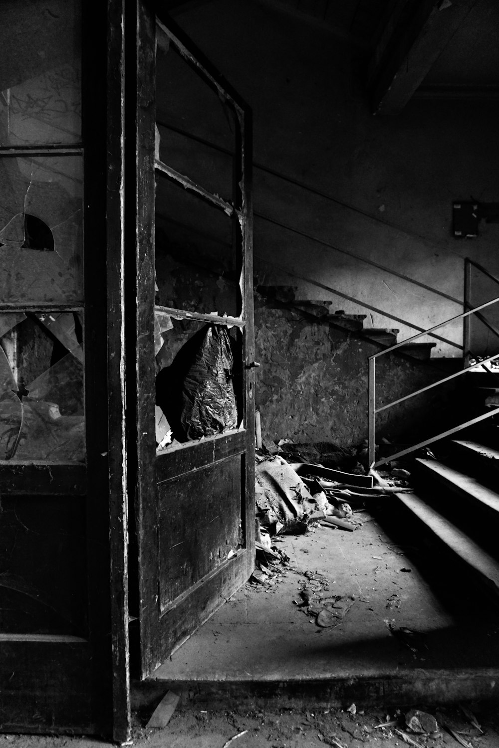 grayscale photo of man in black jacket sitting on stairs