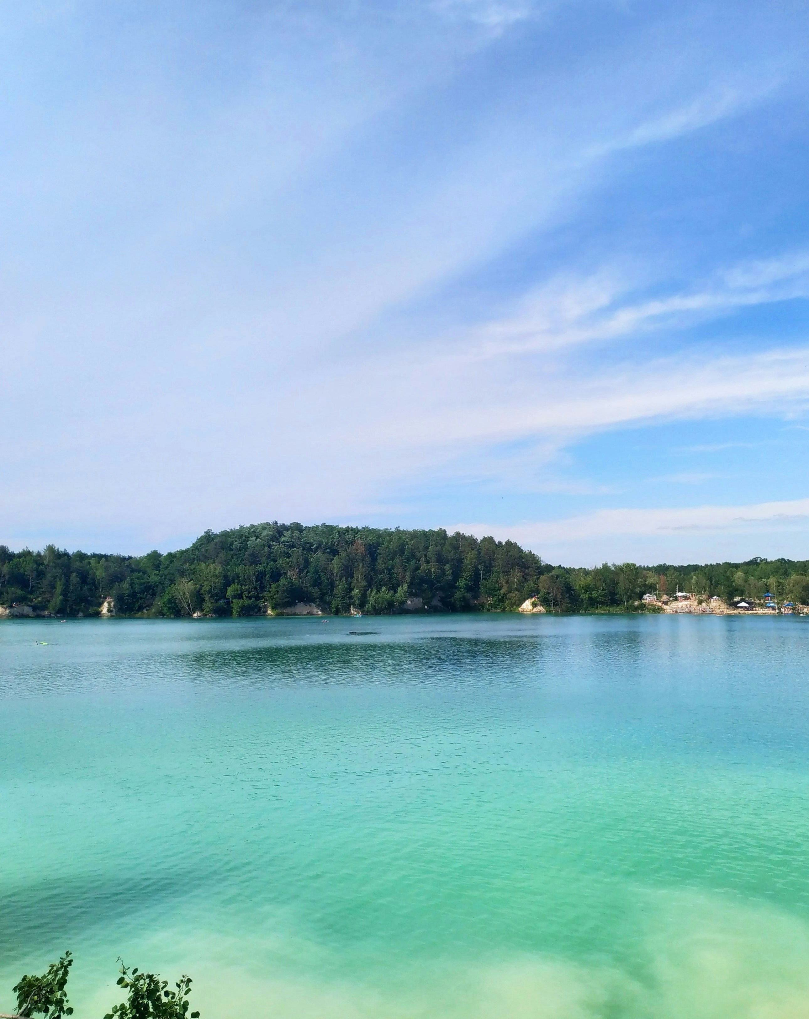 Green trees beside body of water under blue sky during daytime photo ...