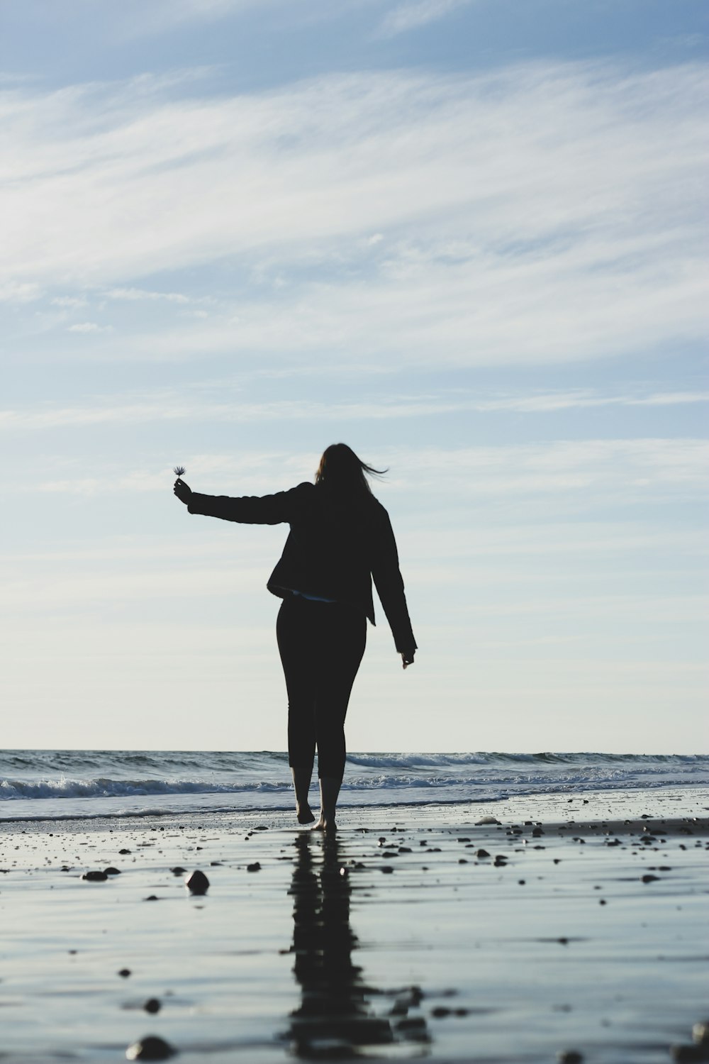 woman in black long sleeve shirt and pants standing on beach during daytime