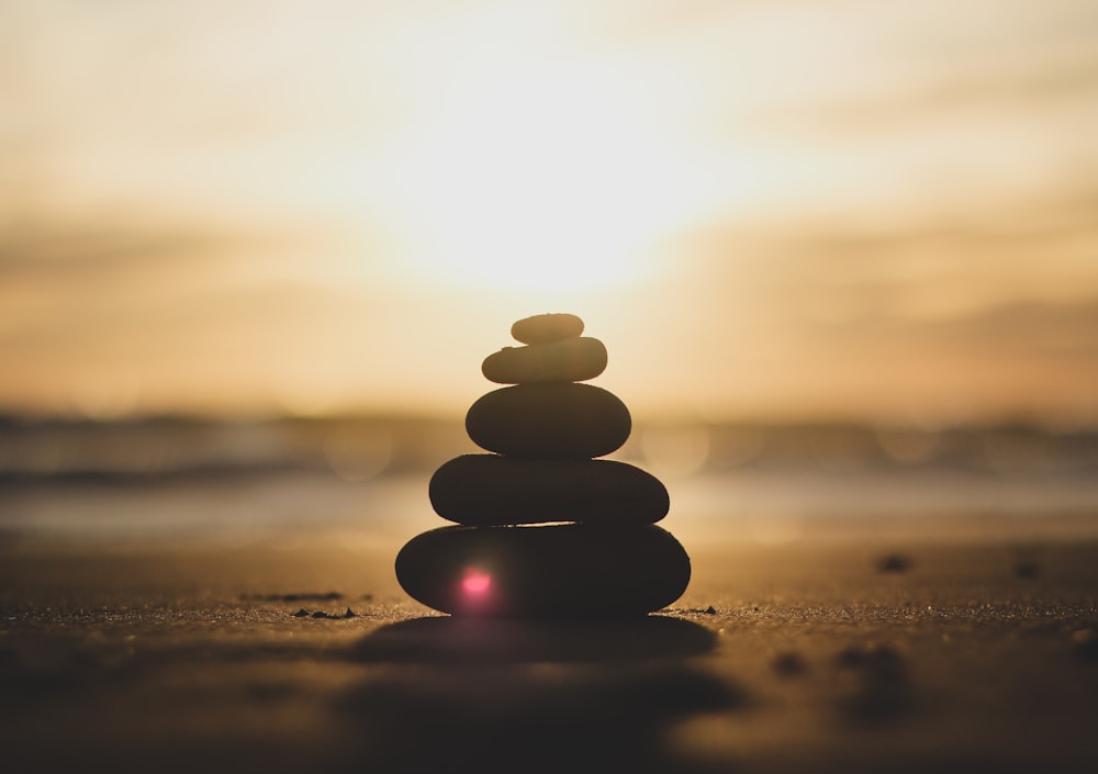 silhouette of stones on beach during sunset