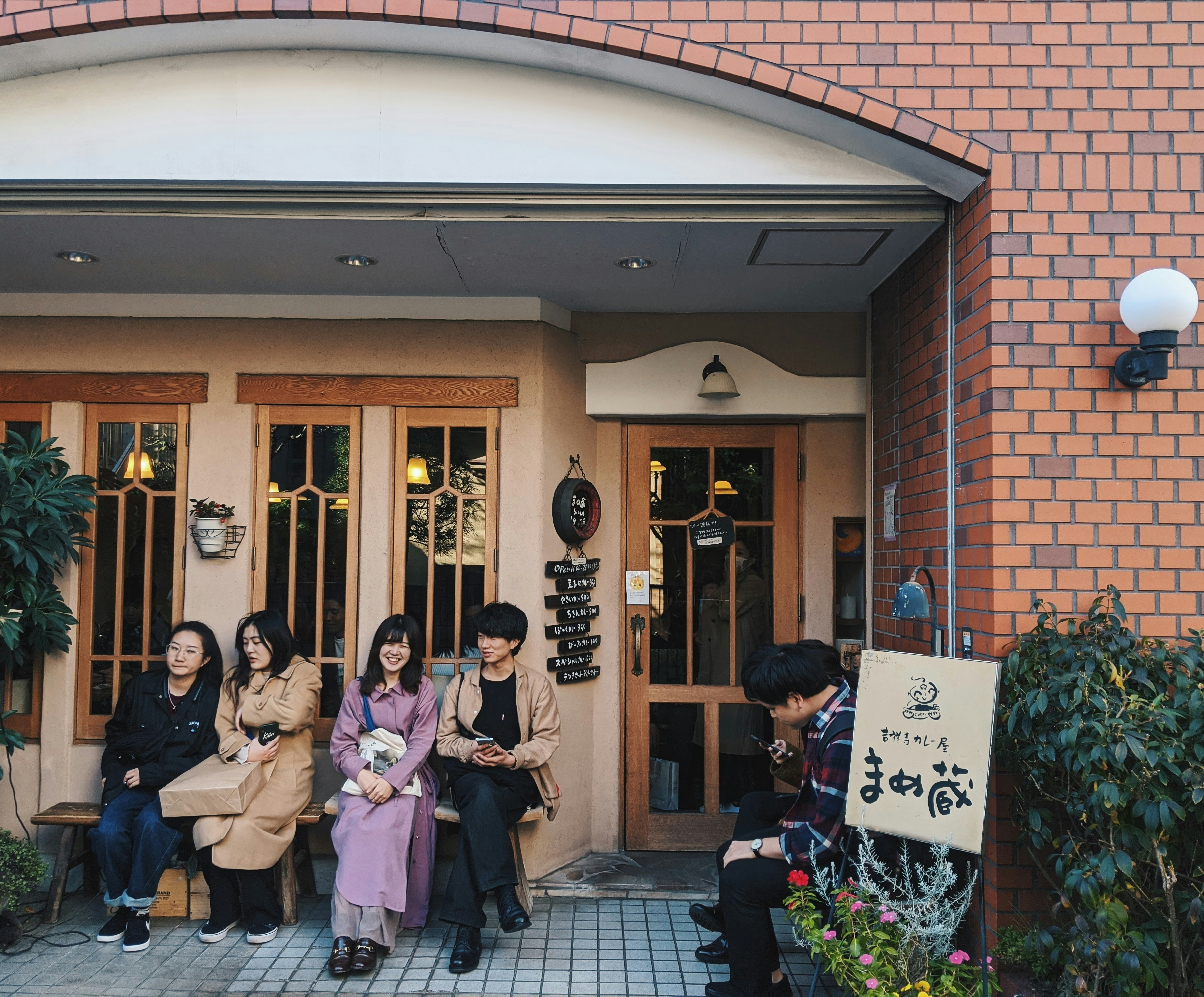 Friends enjoying coffee and conversation in a warm, cozy Japanese cafe