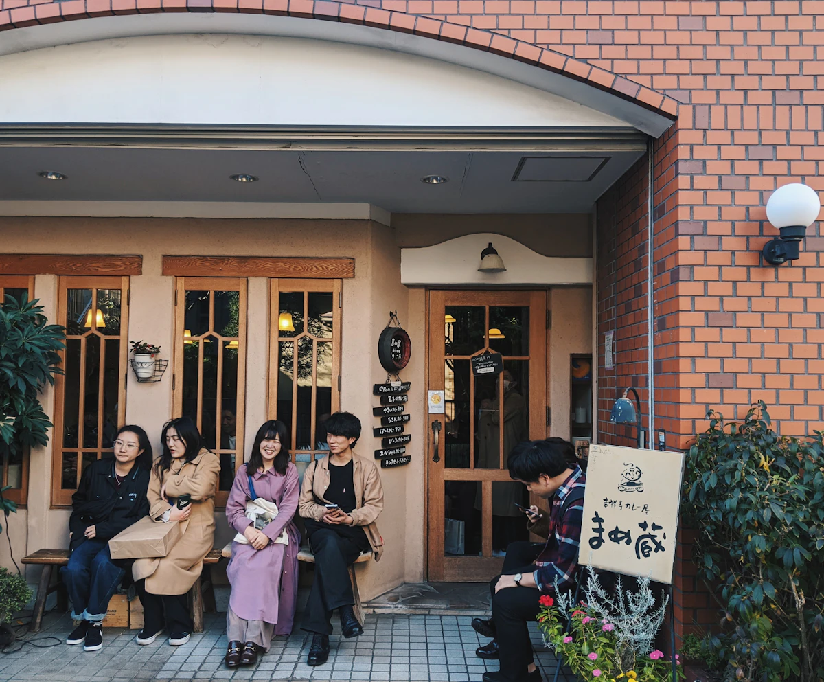 東京のカフェの前で過ごす人々