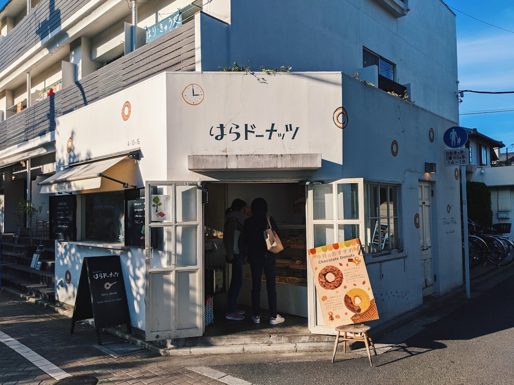 people standing in front of white and blue building during daytime