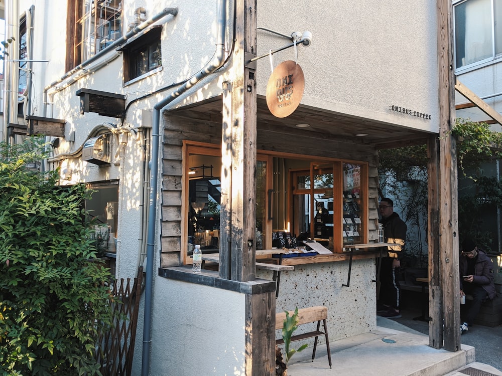 brown wooden table and chairs near white concrete building during daytime