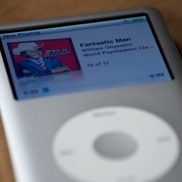 Close-up of a white iPod classic and its click wheel on a brown wooden table
