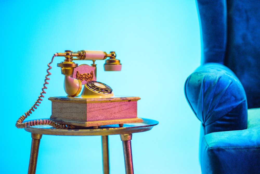 gold rotary phone on brown wooden table