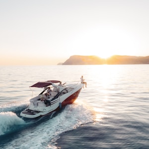 man riding on white and red boat on sea during daytime