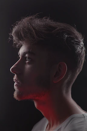 A sharp side profile of a client’s haircut with clean lines and a silver reflector in the background.