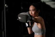 Close-up of a focused athlete mid-boxing punch, sweat glistening, displaying discipline.