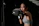 A focused woman in workout gear practicing a powerful punch in a bright training studio.