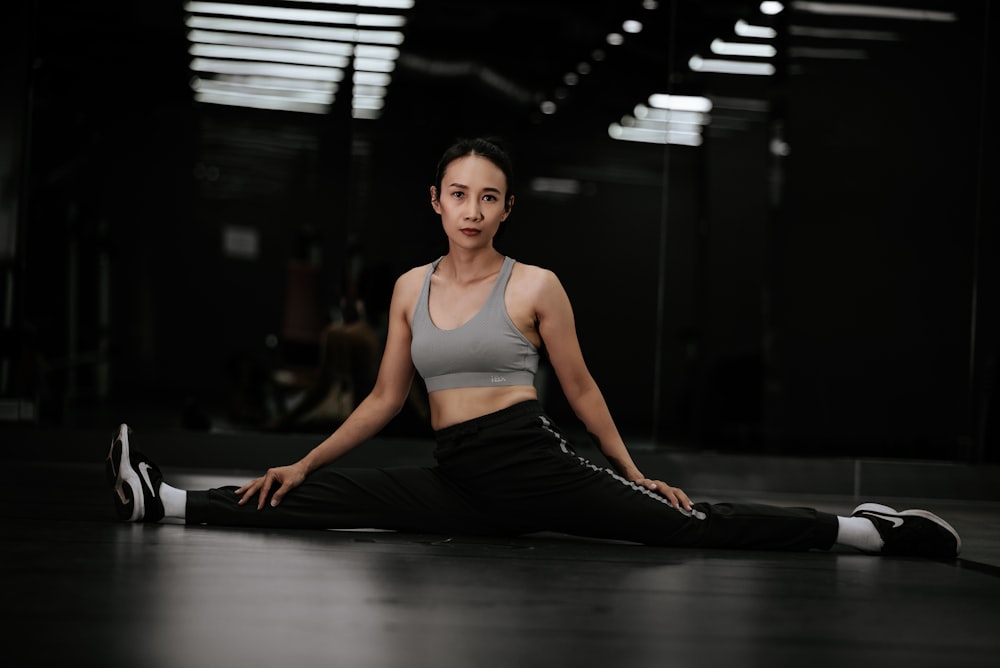 woman in gray tank top and black pants sitting on floor