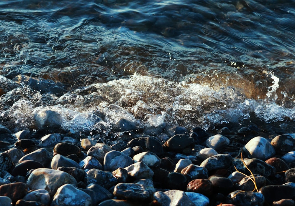 black and gray stones on body of water during daytime