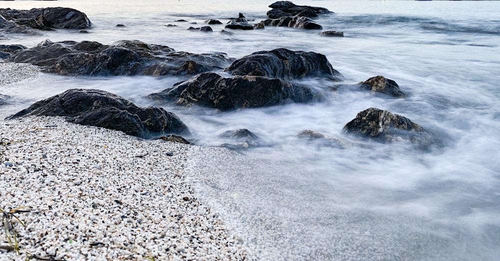 black rock formation on sea shore during daytime