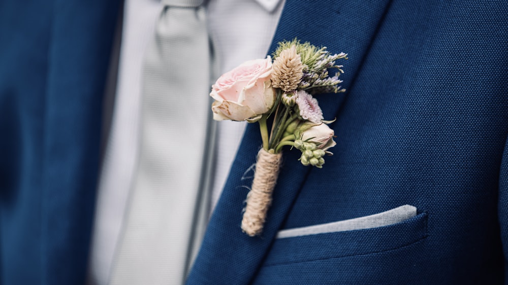 pink rose on blue suit jacket
