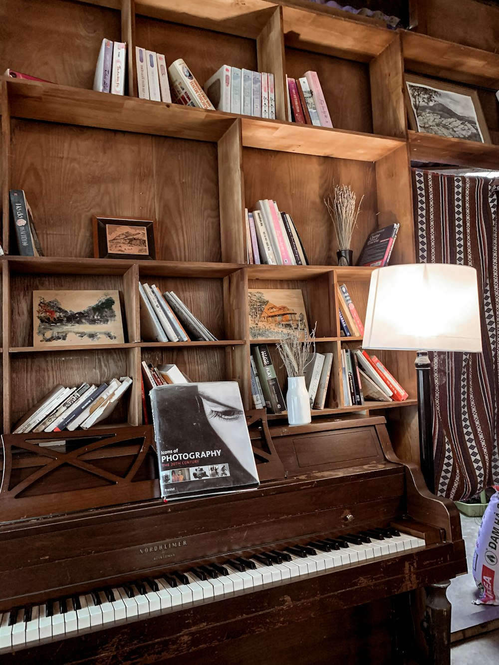 brown wooden upright piano with books