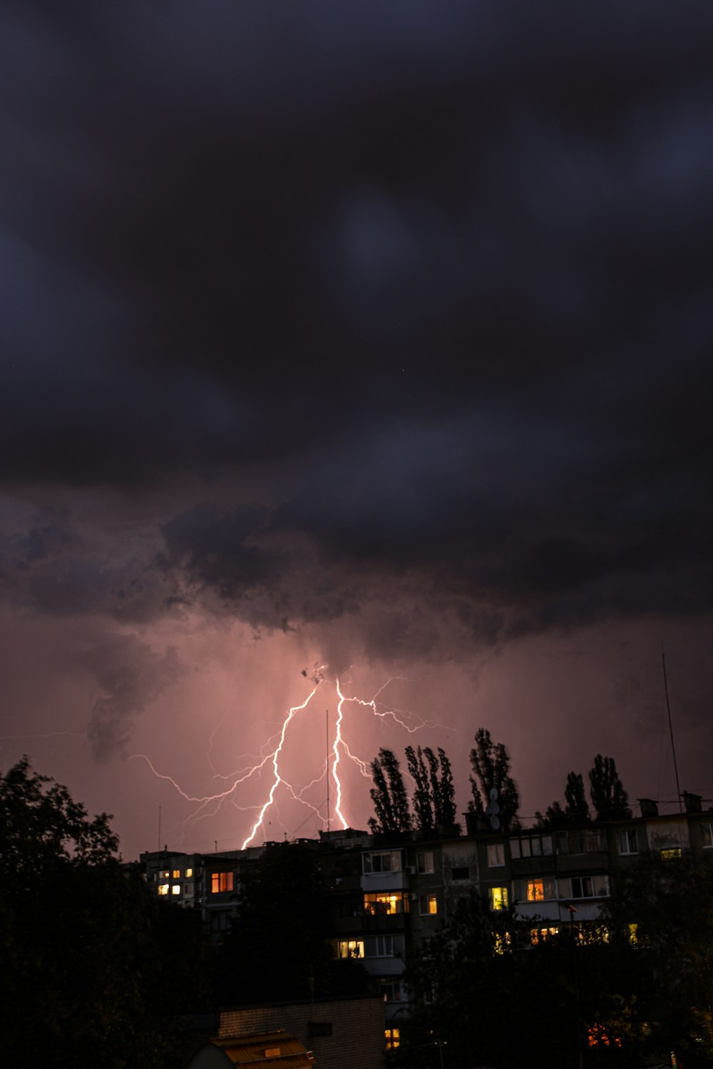 a lightning bolt is seen over a city at night