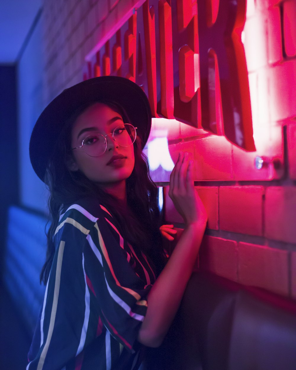 woman in blue and white stripe shirt wearing black hat