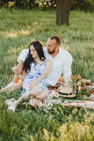 A scenic outdoor setting where couples are enjoying a sunset picnic, relaxed and happy.