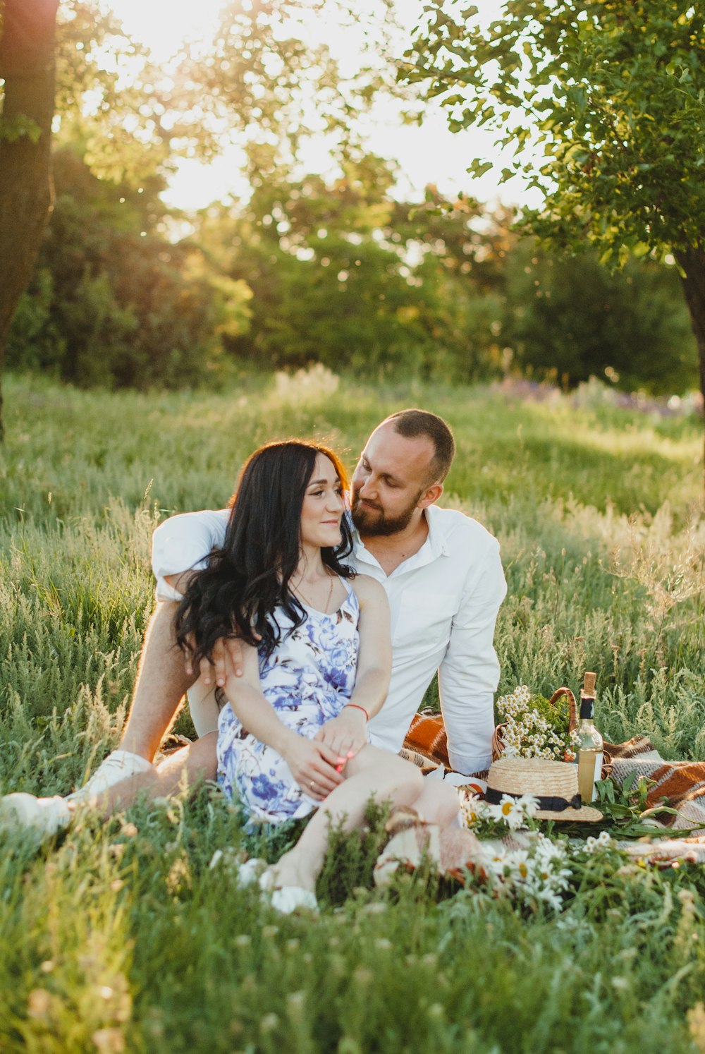 man and woman sitting on grass field during daytime