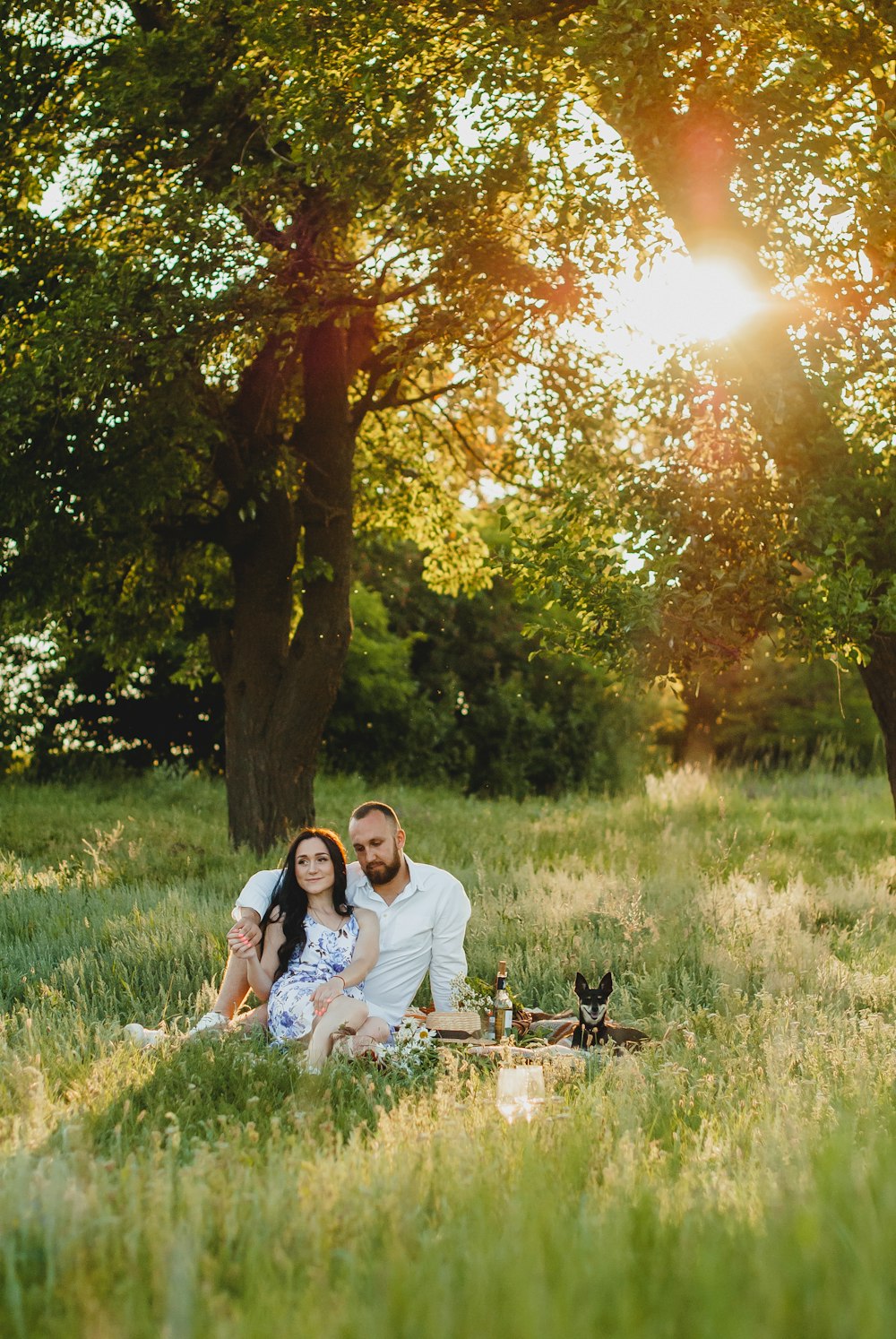 man and woman sitting on grass field during daytime