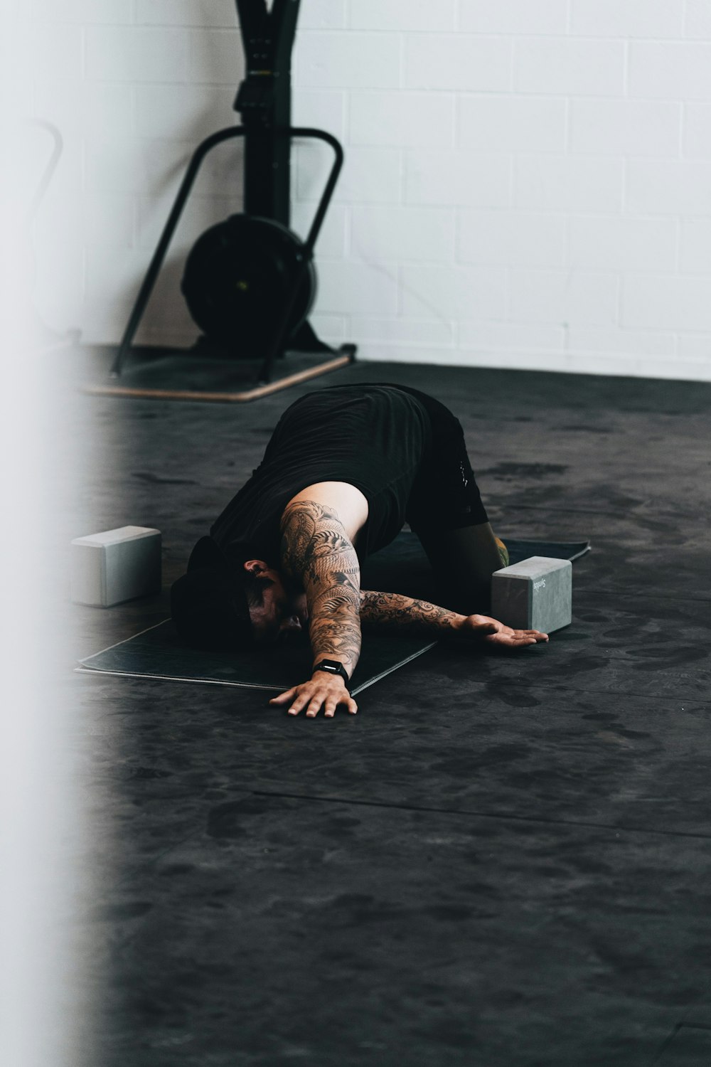 man in black t-shirt and black pants lying on floor