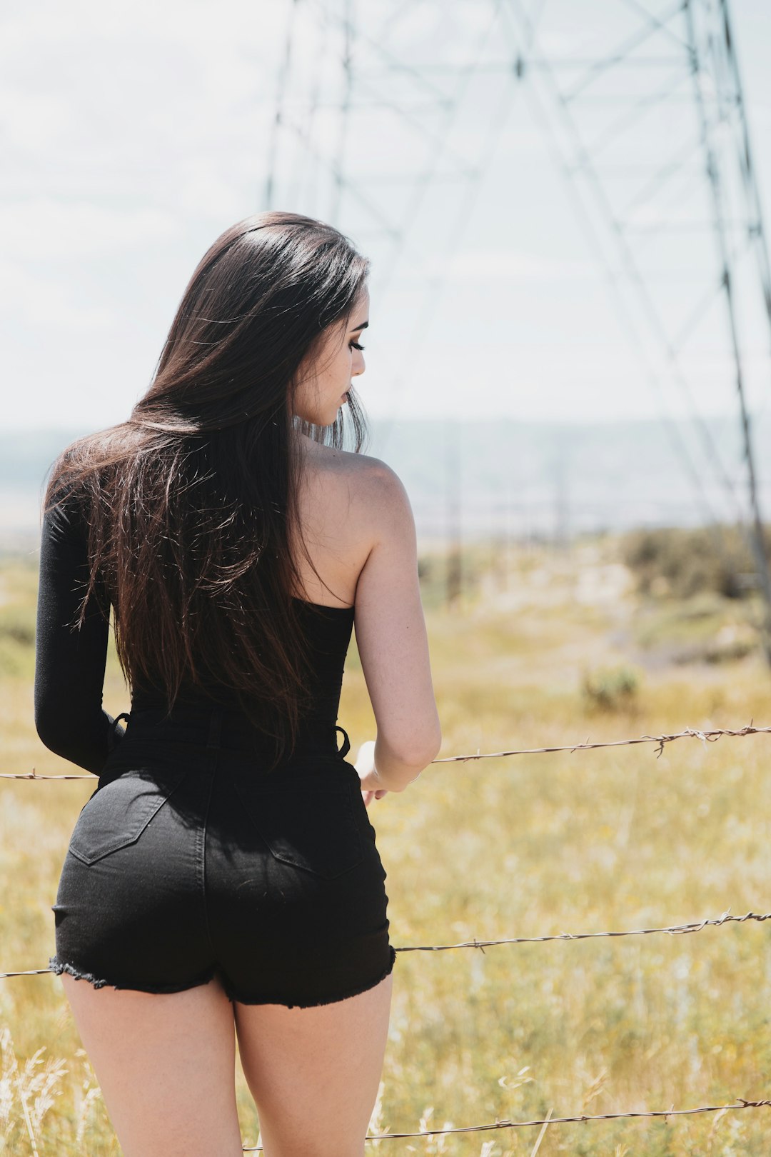 woman in black tank top standing on grass field during daytime