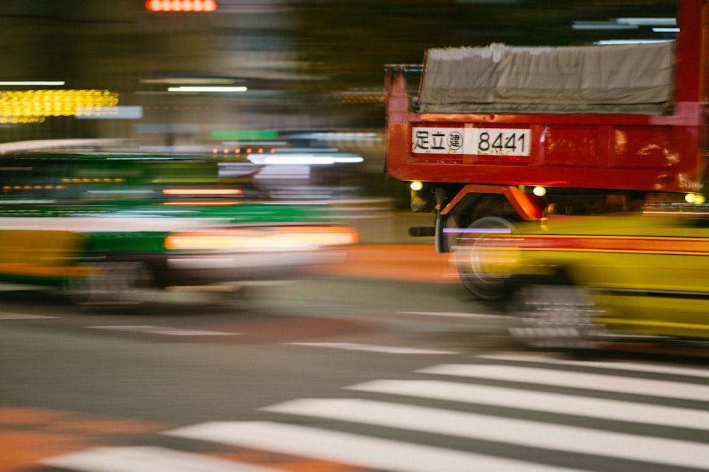 昼間の道路を走る赤いバス