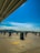 A freshly sealed asphalt parking lot with bright white striping under a clear blue sky.
