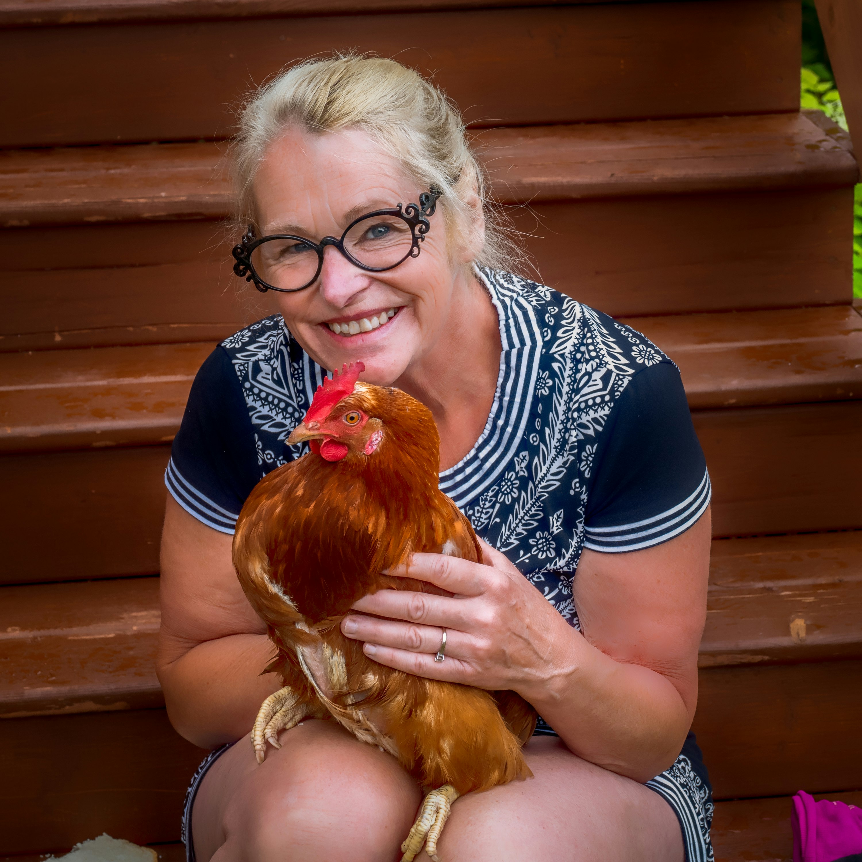 woman in black and white polka dot shirt holding yellow chicken